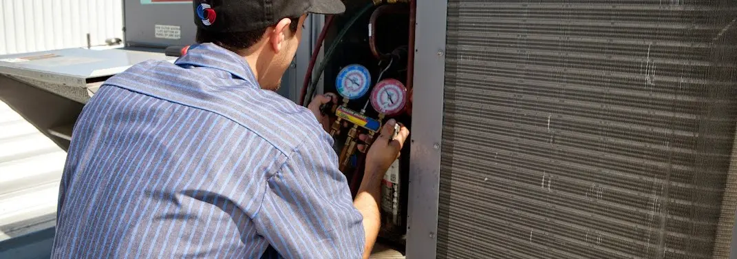 HVAC technician servicing a condenser unit in Jasper